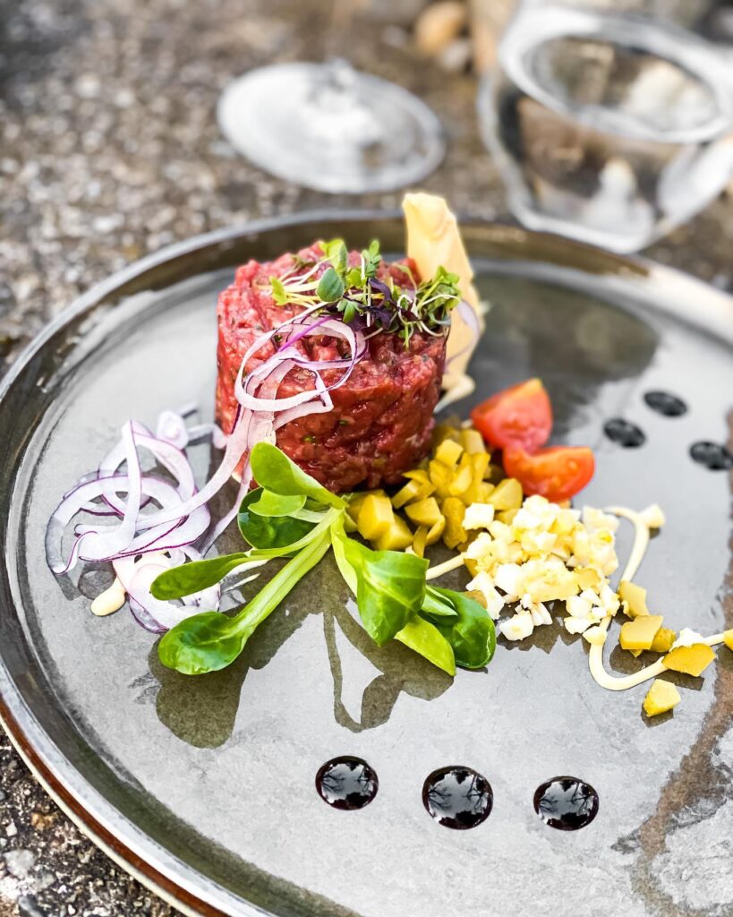 Beef Tatar mit roten Zwiebeln, Kapern, Essiggurke, Vogerlsalat und Balsamico-Perlen – Speisekarte im Landhaus Kainz | Restaurant Südsteiermark, regionale Küche