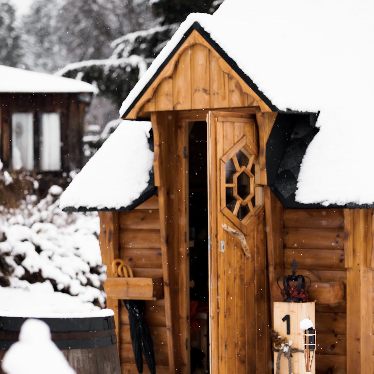Nahaufnahme der finnischen Grillhütte aus Holz, schneebedeckt. Im Landhaus Kainz ist Grillen auch im Winter möglich.