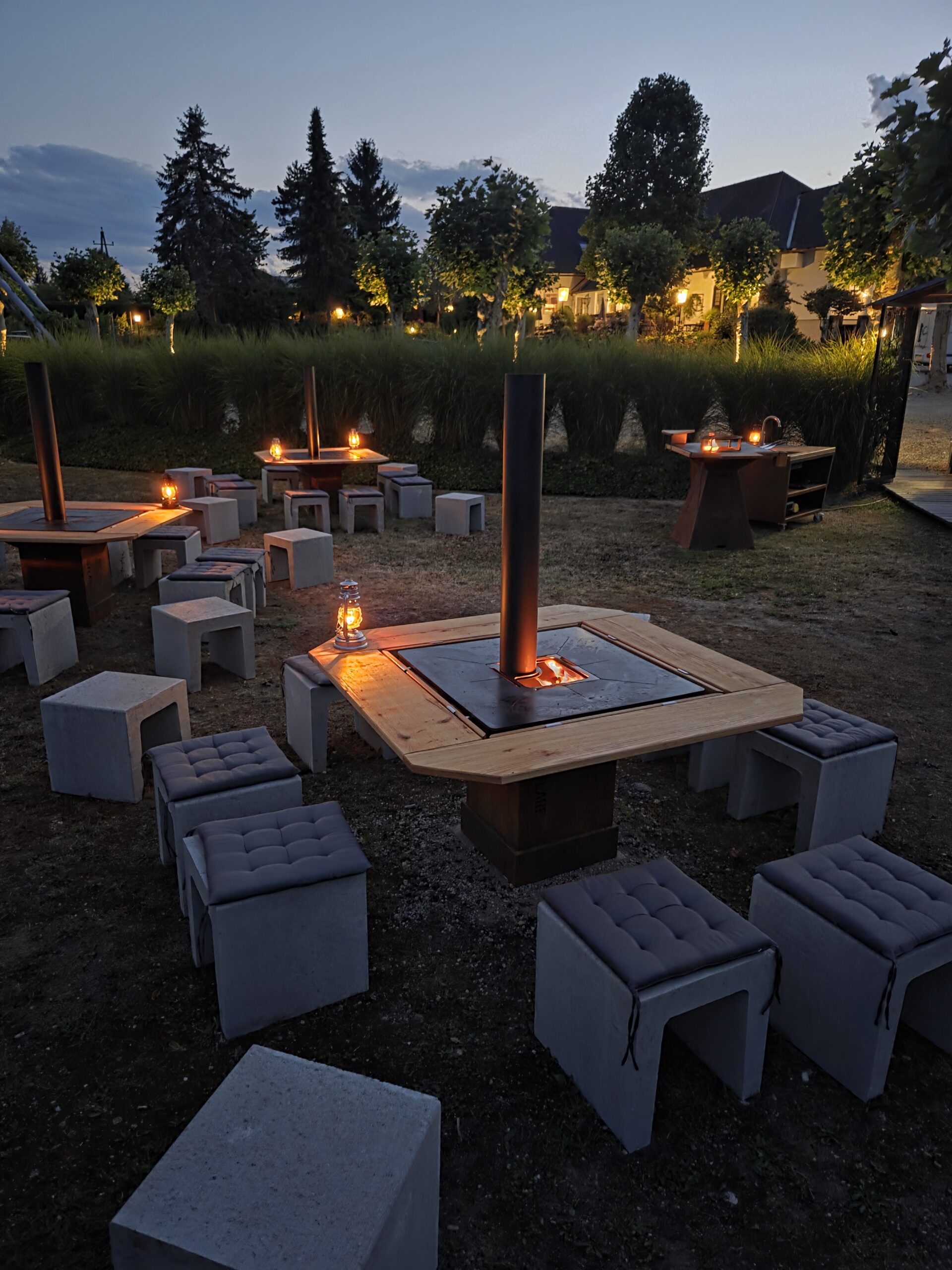 Flare Lounge mit Flare Grill am Landhaus Kainz unter offenem Himmel: Rustikaler Tisch mit gemütlichen Hocker für den perfekten Männerabend